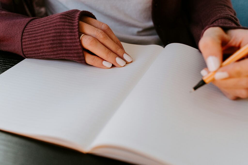 Women beginning to write in a blank notebook